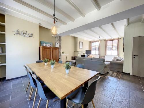 a dining room and living room with a wooden table and chairs at STKE - holiday home for 8 in Veurne