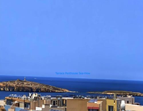 vista su un'isola nell'oceano con edifici di For Rest Aparthotel a San Pawl il-Baħar