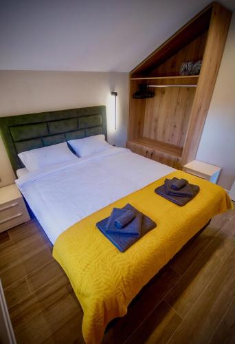 a bedroom with a large bed with towels on it at Aqua Casa in Vrnjačka Banja
