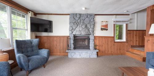 a living room with a fireplace and a tv at Bonnie View Inn in Haliburton