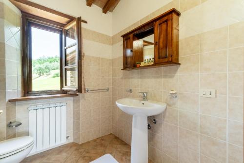 baño con lavabo y aseo y ventana en Pugnano Alto -appartamento Castagna, en Lisciano Niccone