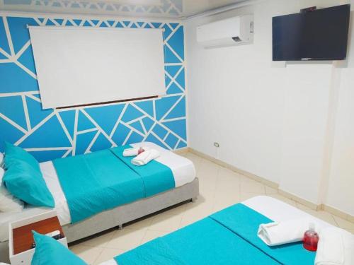 1 dormitorio con 2 camas y pantalla en blanco en Apartamento cerca al Centro Histórico en Edificio frente a la playa A-3-5, en Cartagena de Indias