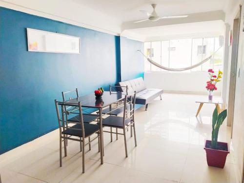 ein Esszimmer mit blauen Wänden sowie einem Tisch und Stühlen in der Unterkunft Apartamento cerca al Centro Histórico en Edificio frente a la playa A-3-5 in Cartagena de Indias