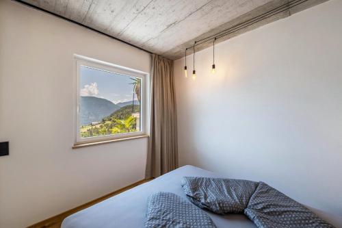 a bedroom with a bed and a window at Thalerhof Naturae Oasis Ritten in Auna di Sotto