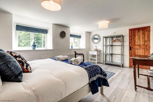 1 dormitorio con 1 cama blanca grande y escritorio en Meadow Cottage en Bicester