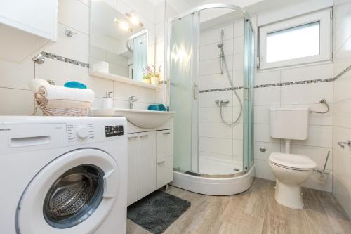a washing machine in a bathroom with a toilet and a shower at VILLA DONNA in Pridraga