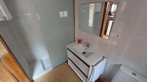 y baño con lavabo, aseo y espejo. en Casa vacacional de pueblo, en A Ponte do Porto