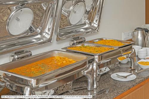 two metal pans filled with food on a kitchen counter at Treebo Sapphire Studio in Nashik