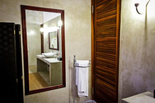 a bathroom with a mirror and a sink and a mirror at Otjiwa Safari Lodge in Otjiwarongo