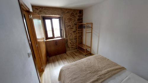 Habitación pequeña con cama y ventana en Casa vacacional de pueblo, en A Ponte do Porto