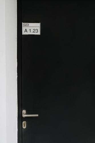 a black door with a sign on it at Butique Apartman in Balatonlelle