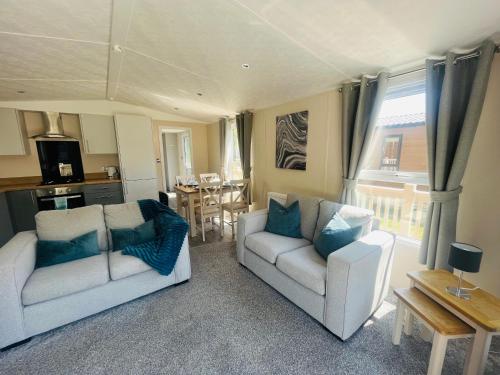 een woonkamer met twee witte banken en een tafel bij Tarn Lodge with Hot Tub in York
