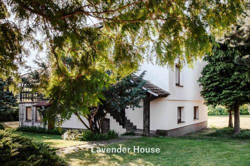 a white house with trees in front of it at Lavender House in Osieki