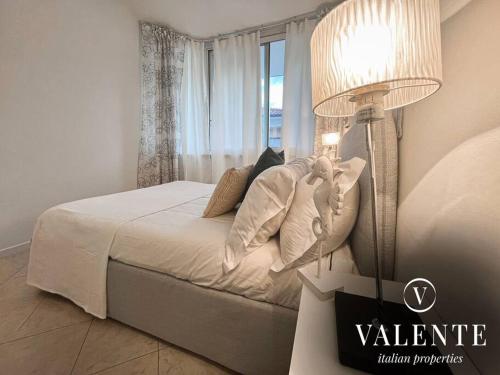 1 dormitorio con 1 cama con lámpara y ventana en Casa al Mare - Torre del Lago- Valente Italian Properties, en Torre del Lago Puccini