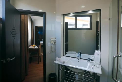 a bathroom with a sink and a large mirror at Central Hotel Tana in Antananarivo