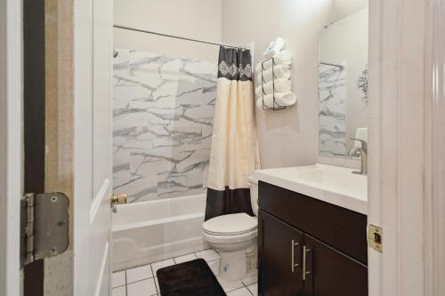 a bathroom with a toilet and a sink and a tub at Queen G Investments apts in Detroit