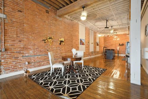 a room with a table and chairs and a brick wall at Queen G Investments apts in Detroit