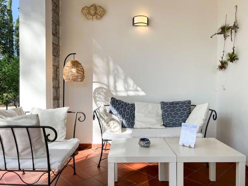 a porch with a white couch and a table and chairs at Hotel Brigantino in Procchio
