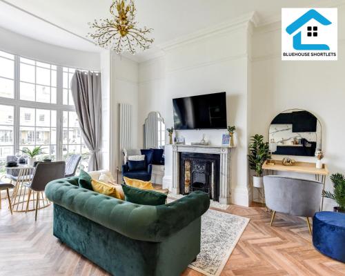 a living room with a green couch and a fireplace at Cosy Brighton Winter Retreat by the Sea-Marine FFF by Bluehouse Shortlets Brighton in Brighton & Hove