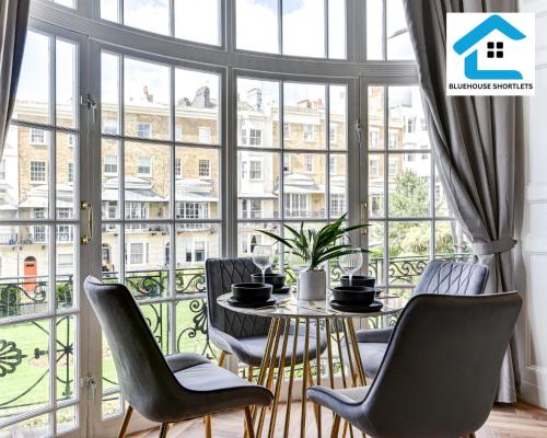 a room with a table and chairs and a large window at Cosy Brighton Winter Retreat by the Sea-Marine FFF by Bluehouse Shortlets Brighton in Brighton & Hove