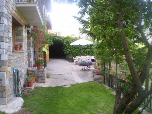 a patio with a table and an umbrella in a yard at Hostal Pernalle in Erill la Vall