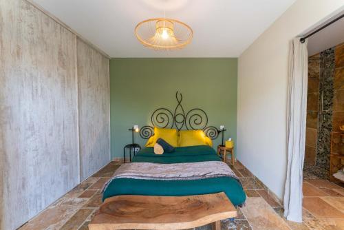 a bedroom with a bed with a green wall at Villa La Mireio in Malaucène