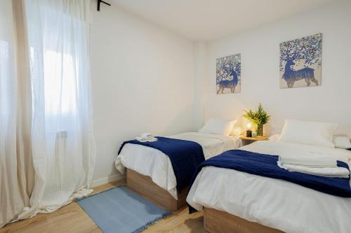 1 dormitorio con 2 camas y ventana en GENESIS APARTMENT IN MADRID, en Madrid