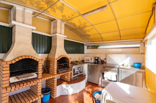 a kitchen with a brick oven in the middle at Apartamentos Pátio Victória by Umbral in Vila Nova de Milfontes