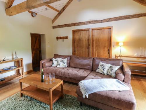 a living room with a brown couch and a table at Nant Glas in Llanwrda