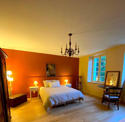 1 dormitorio con 1 cama con pared de color naranja en Chambres d'hôtes de charme avec piscine - Le Clos Boissiere, en Valence-sur-Baïse