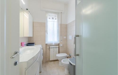 Baño blanco con lavabo y aseo en Stunning Apartment In Recco With Kitchen, en Recco