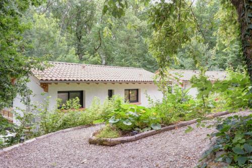 a house in the woods with a gravel driveway at PAUSE NATURE. Maison Ananda à 14 kms de Toulouse avec parking privatif in Lapeyrouse-Fossat
