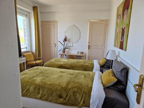 une chambre d'hôtel avec deux lits et une chaise dans l'établissement Villa Fresquet, à Cherbourg en Cotentin