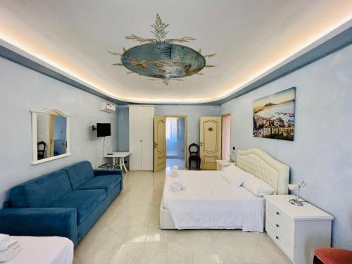 1 dormitorio con 1 cama y 1 sofá azul en Be Your Home - Villa Rosi, en Civitavecchia