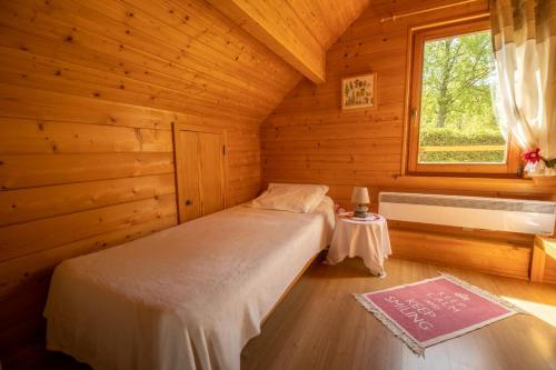 a bedroom with a bed in a log cabin at Chalet Le Pin à 2 pas de GERARDMER, dans la vallée des lacs in Xonrupt-Longemer