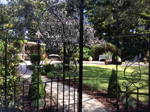 a gate to a garden with a park behind it at Meifod House in Caernarfon