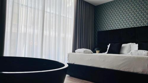 a bedroom with two beds and a large window at Palazzo Gatto Bianco in Bari