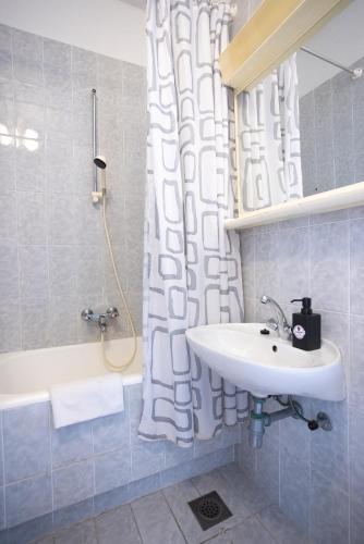 a bathroom with a sink and a shower with a tub at Apartments Lonzor in Selce