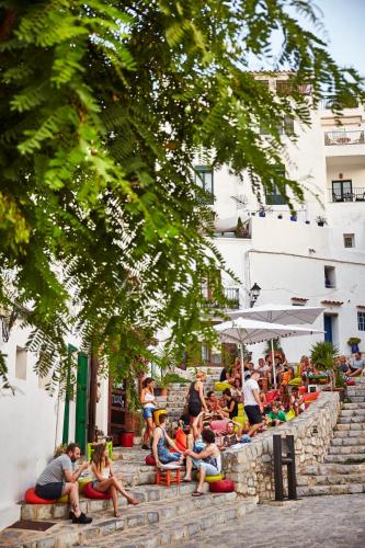 a group of people sitting on the stairs in a crowd at 7Pines Resort Ibiza, part of Destination by Hyatt in San Jose