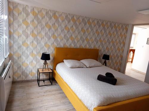 1 dormitorio con 1 cama con sombrero en MONTALIEU SEJOUR Rez de jardin Les jonquilles - 1 à 4 PERS - PROX CNPE BUGEY - VALLEE BLEU - VIA RHONA, en Montalieu-Vercieu