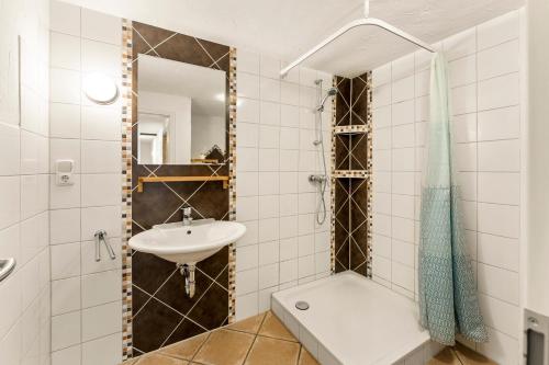 a bathroom with a sink and a toilet and a mirror at Grashaus Upleward in Krummhörn