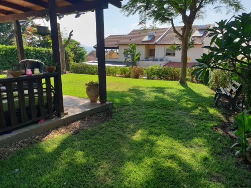 a yard with a house in the background at פינה שלווה בטבע- A peaceful spot in nature in Bet HaShitta
