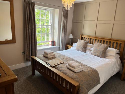 um quarto com uma cama grande e toalhas em The Temple Bar Inn em Hereford