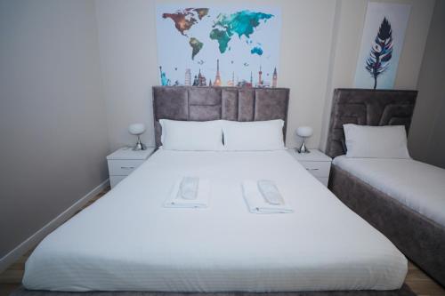 a bedroom with a large white bed and a map on the wall at Miku Apartment -Outstanding Apartment at Taiwan in Tirana