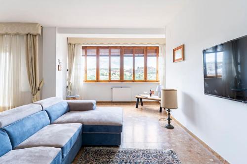 salon z niebieską kanapą i telewizorem w obiekcie Casa San Saturnino appartamento 8 posti Cagliari centro w Cagliari