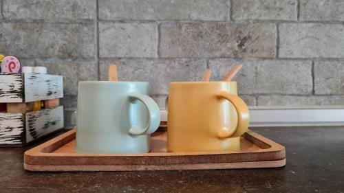 two coffee mugs sitting on a wooden tray at ILIS House Matka in Skopje