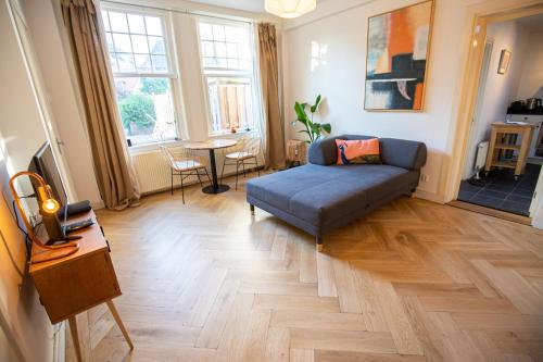 a living room with a couch and a table at Cute Beach House Zandvoort in Zandvoort