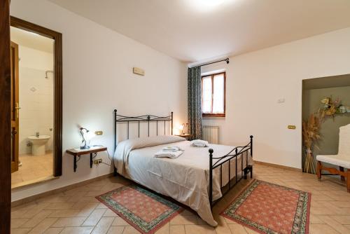 um quarto com uma cama e um espelho e uma casa de banho em Pugnano Alto - appartamento Grano em Lisciano Niccone