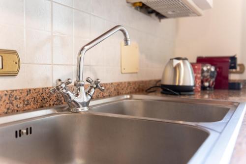 um lavatório de aço inoxidável numa cozinha em Pugnano Alto - appartamento Grano em Lisciano Niccone