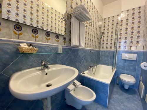 a bathroom with a sink and a toilet at Hotel Due Palme in Mergozzo